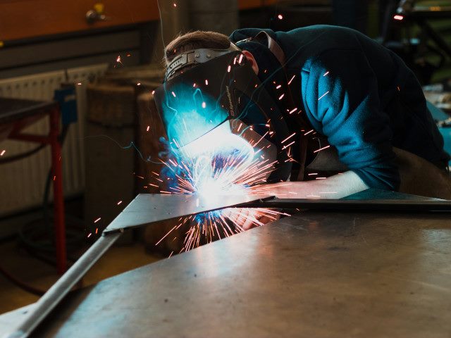 A worker welds metal components.