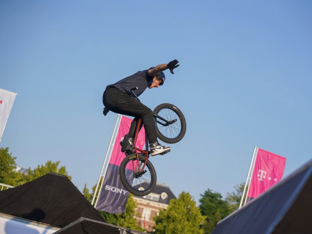 A BMX rider does a trick at a competition.