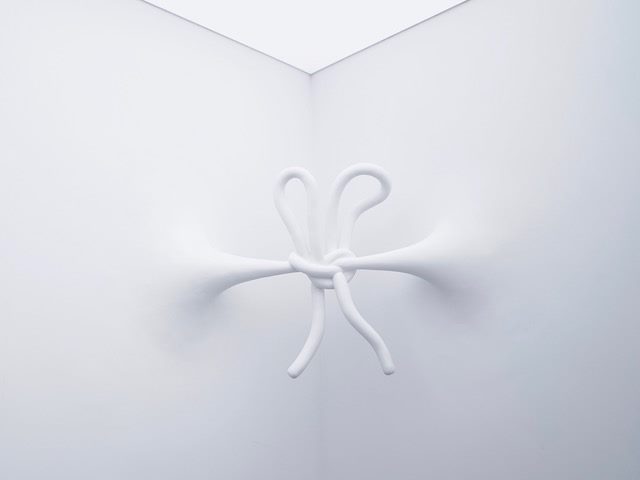 abstract art sculpture. white sculpture on white background of bow tie knotted together