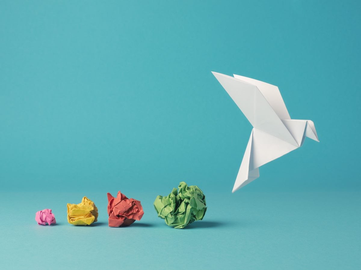 Colorful crumpled paper balls with an origami dove
