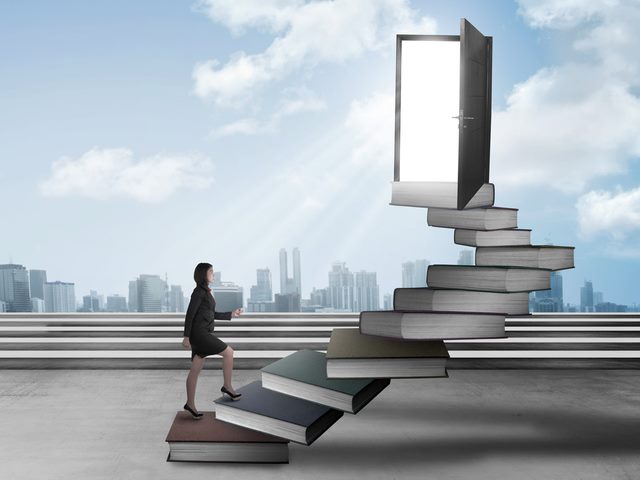 CMO marching up a stairway made of books to an open door with sunlight pouring out