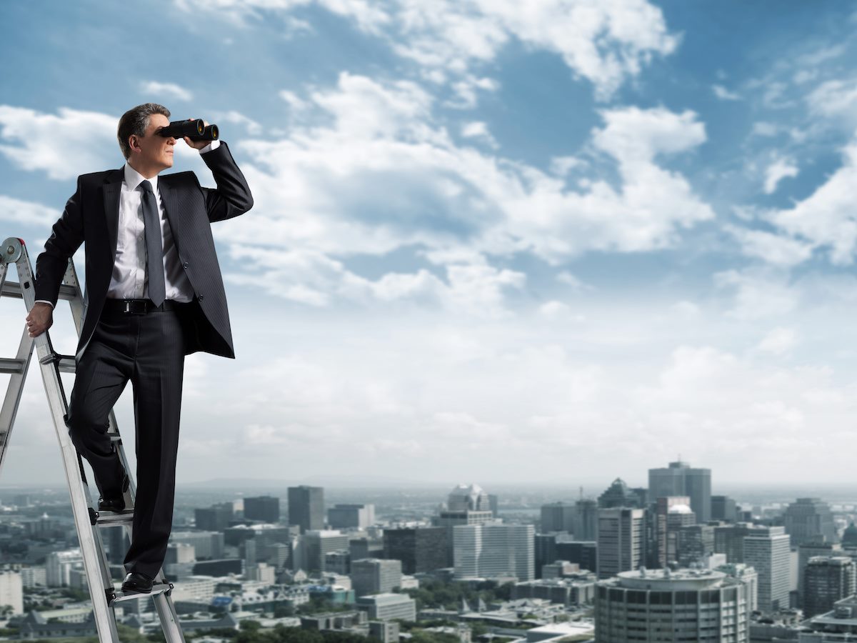 A Business man with binoculars standing on a ladder and overlooking a city