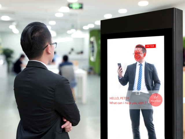 A person standing in front of an interactive digital sign
