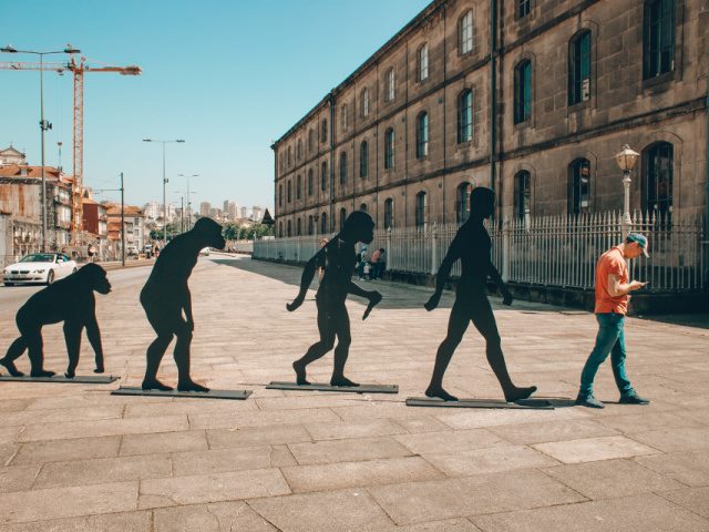 photo of evolution stages with man holding a mobile phone at the end