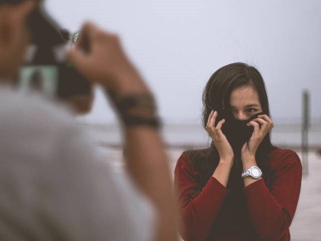 woman hiding her face partially behind a turtleneck