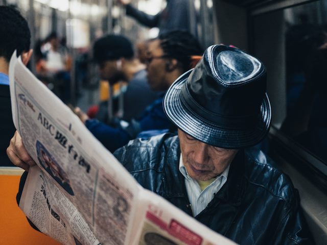 man reading paper on the subway