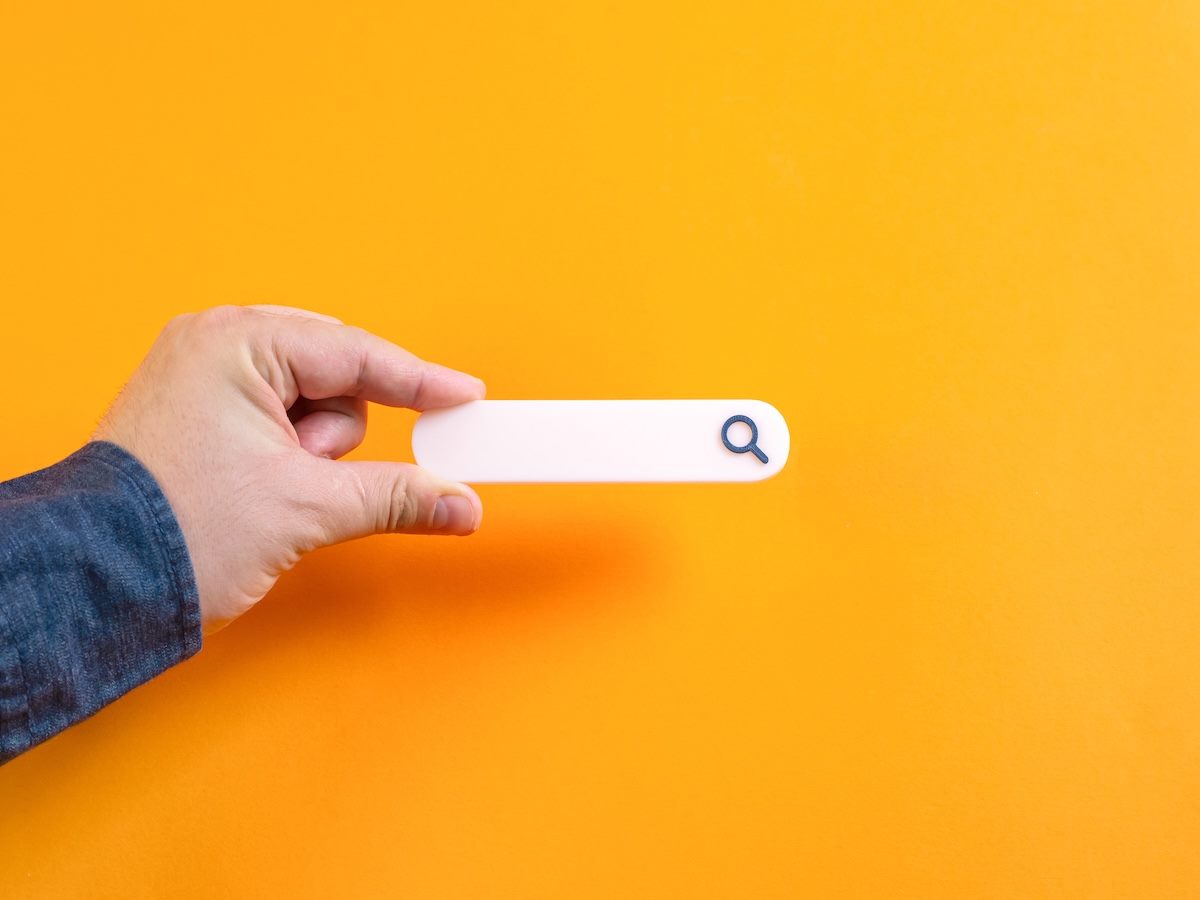 a person's hand "holding" an online search bar 