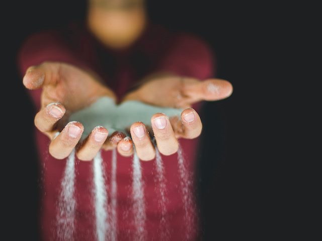 sand sifting through a person's hands