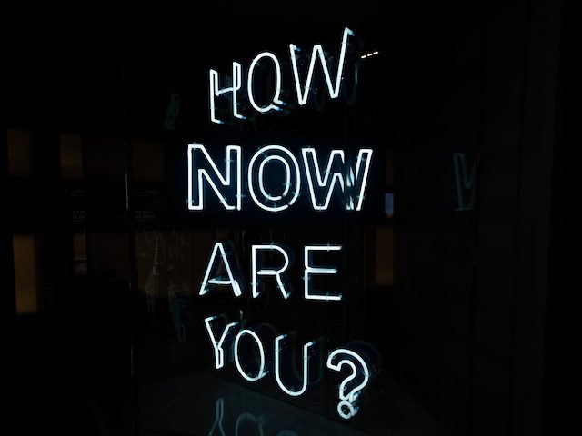 neon sign reading: "How Now Are You?"