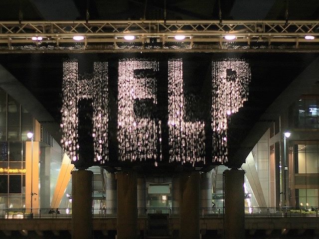 shimmery help sign hanging from front of building