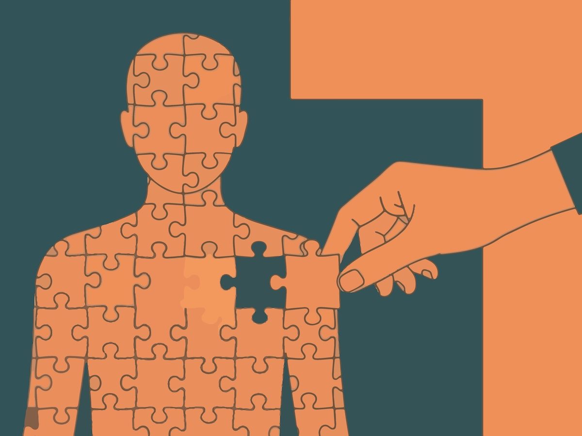 Mental health support concept with hand completing human puzzle