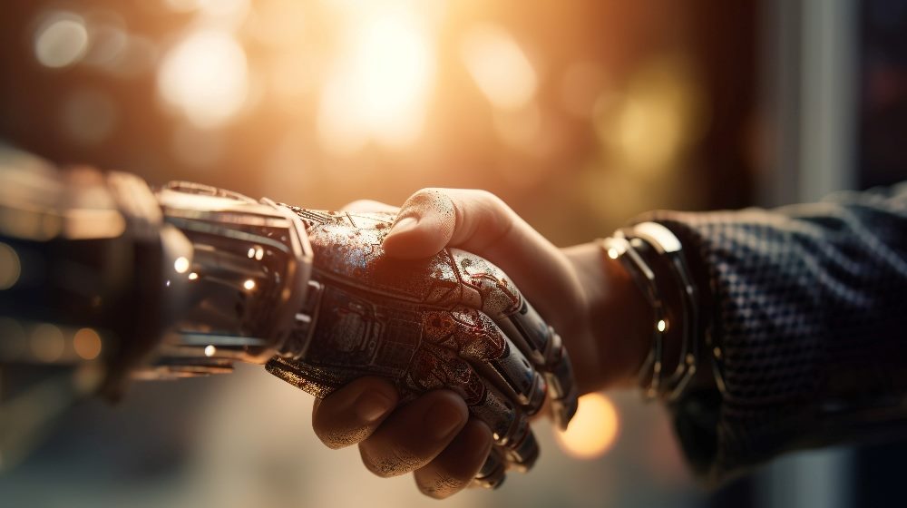 A robot hand embraces they hand of a businessman wearing a suit, suggesting the need for a deliberate approach for AI in business.