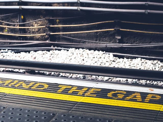 Yellow "mind the gap" sign at train station