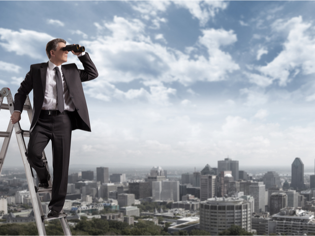 A man on a ladder looking through a telescope at a cityscape - future concept