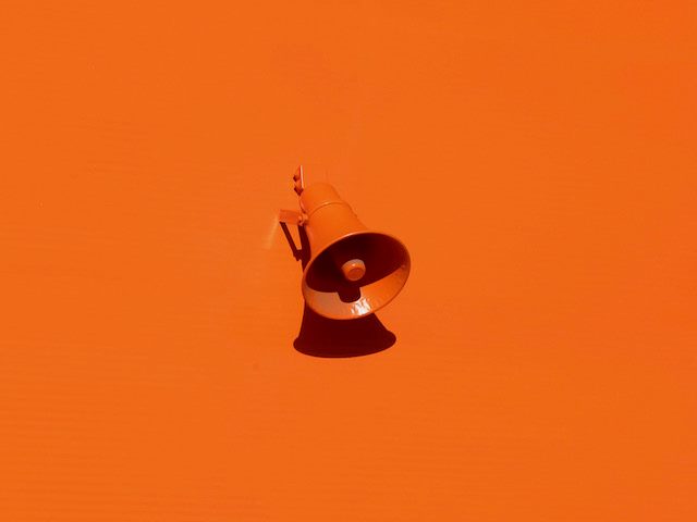 orange megaphone against an orange wall