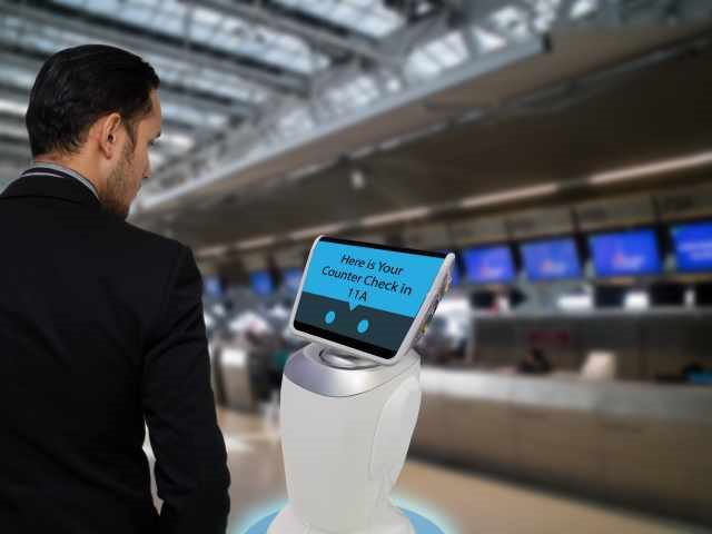 Man interacting with chatbot kiosk at airport