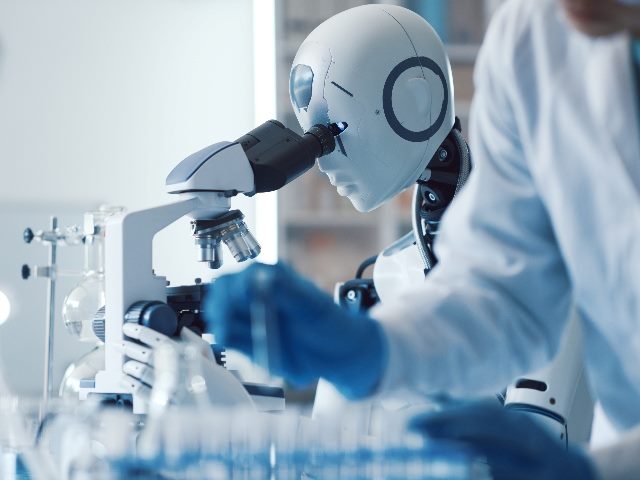 Woman and android robot in the science lab, as the robot looks into a microscope.