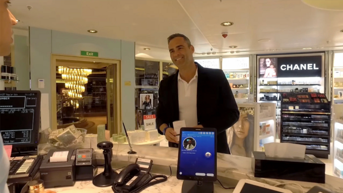 A cruise guest using their OceanMedallion for contactless payment at a gift shop