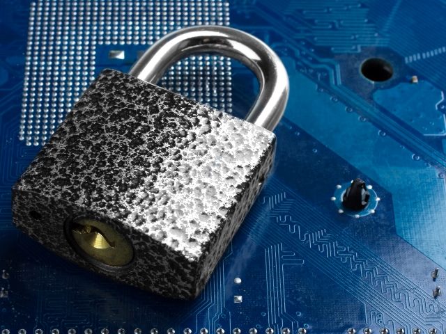 A metal padlock lies on the background of a blue mother board. 