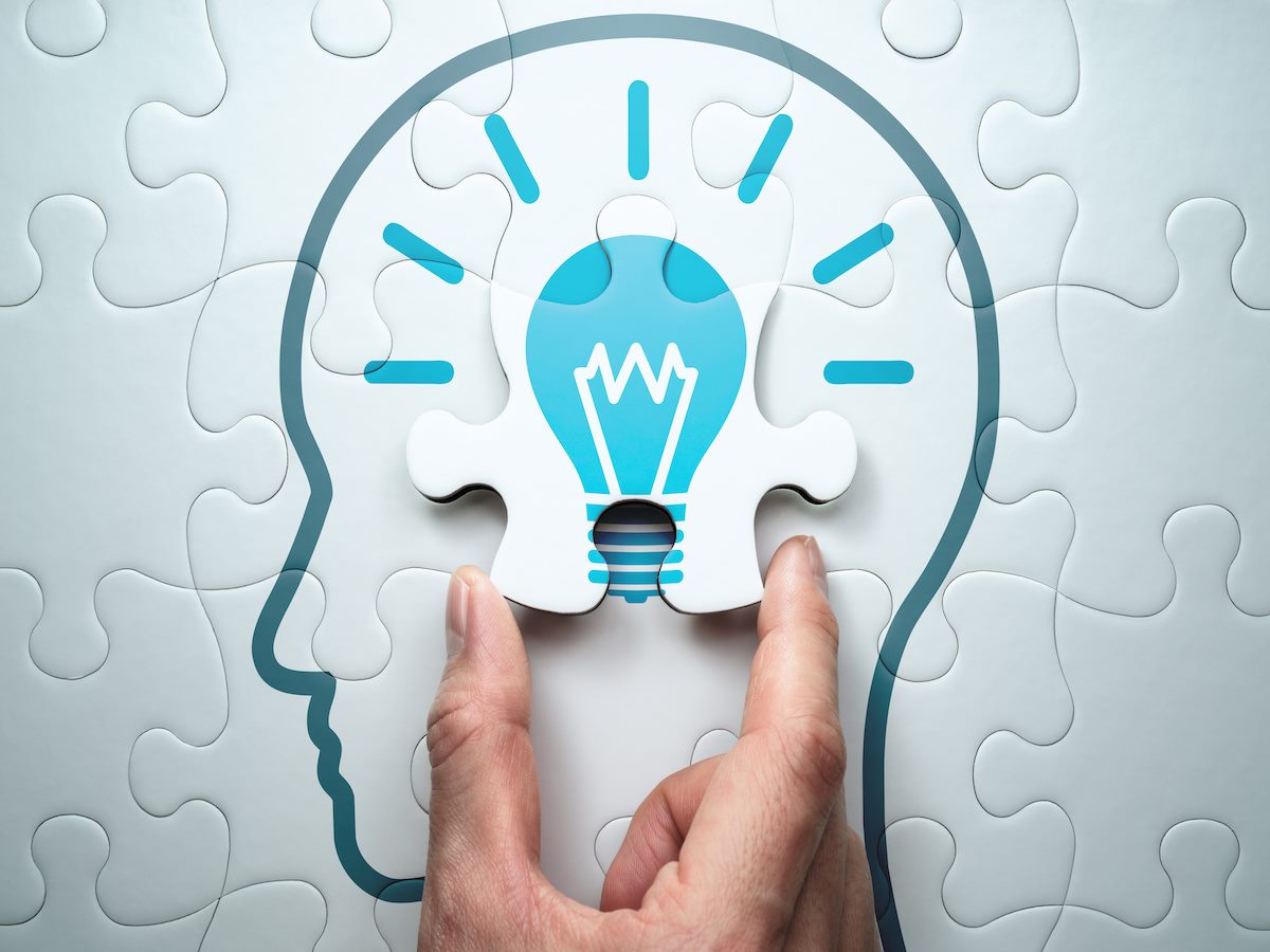 A jigsaw puzzle of a head outline with a lightbulb inside