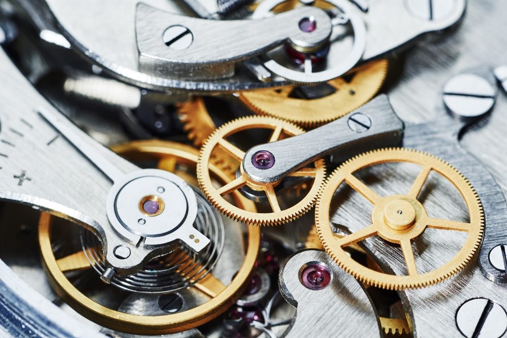 Close-up view of intricate watch gears and mechanisms, highlighting the precision and complexity of the interlocking parts in piece about AI in customer experience in healthcare settings.