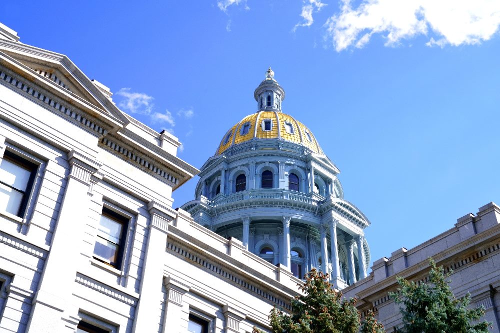 The image shows the dome of the Colorado State Capitol building against a clear blue sky, symbolizing legislative progress. The photo is relevant to discussions about Colorado's AI law, highlighting the state's pioneering efforts in AI regulation.