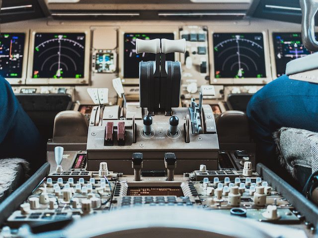 close up of the cockpit of an airplane with the pilot and copilot's legs visible. 