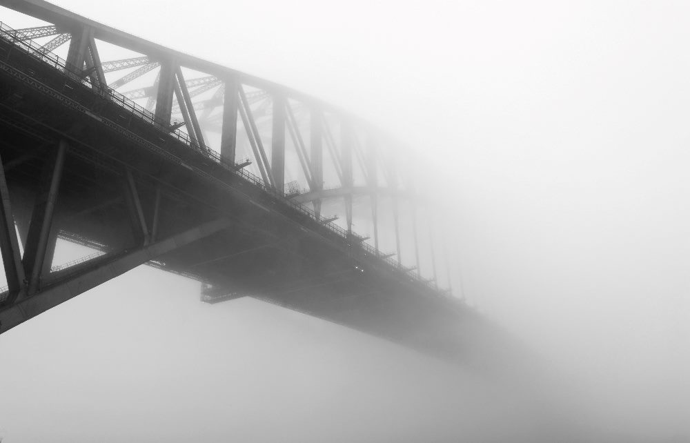 Sydney Harbour Bridge under the mist in black and white in a piece about AI trust.