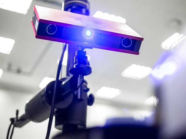 Professional 3D scanner scanning an industrial object plastic molding placed on a turntable.