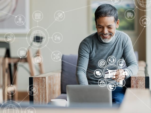 Man on computer smiling while shopping online