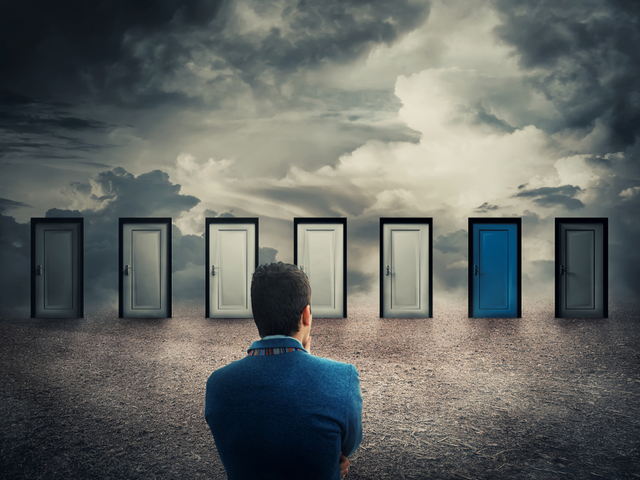 A man looking at multiple doorways trying to select the correct door to go through - vendor selection concept