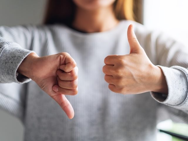 a woman with one thumb up and one thumb down