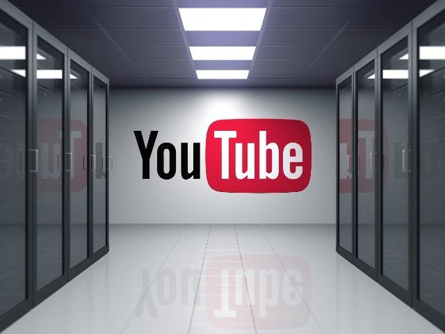 Red black and white YouTube logo and name on thegray  wall of the server room with glass doors on each side, in piece explaining YouTube channel analytics.