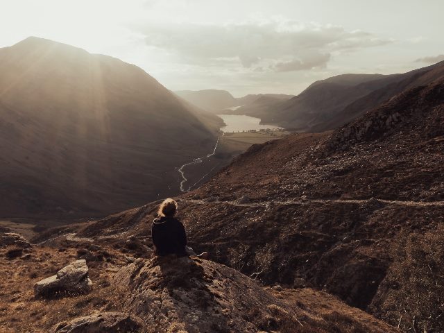 Person enjoying sunset in mountains in Lake District.