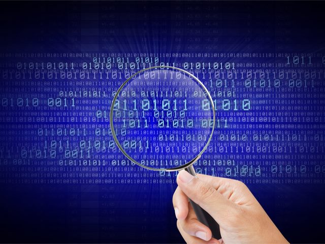 A magnifying glass looking through code and datasets