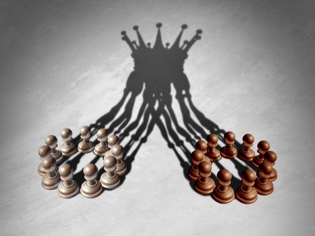Chess pawns forming a king crown cast shadow - Leadership concept