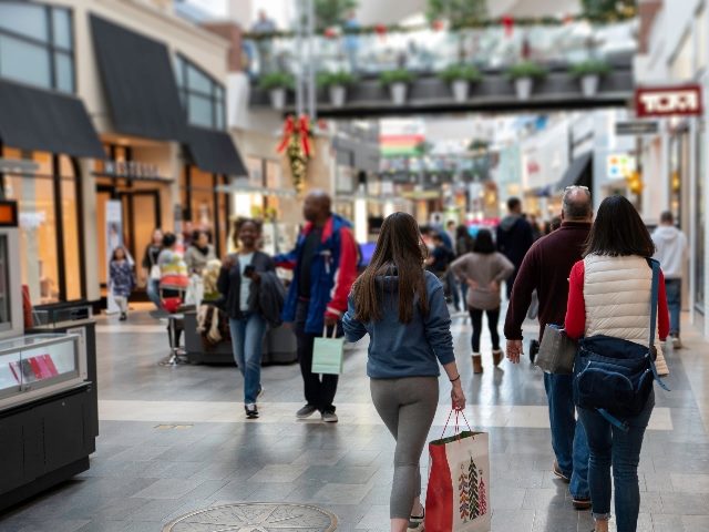 Shoppers walk through a crowded mall a few days before Christmas.