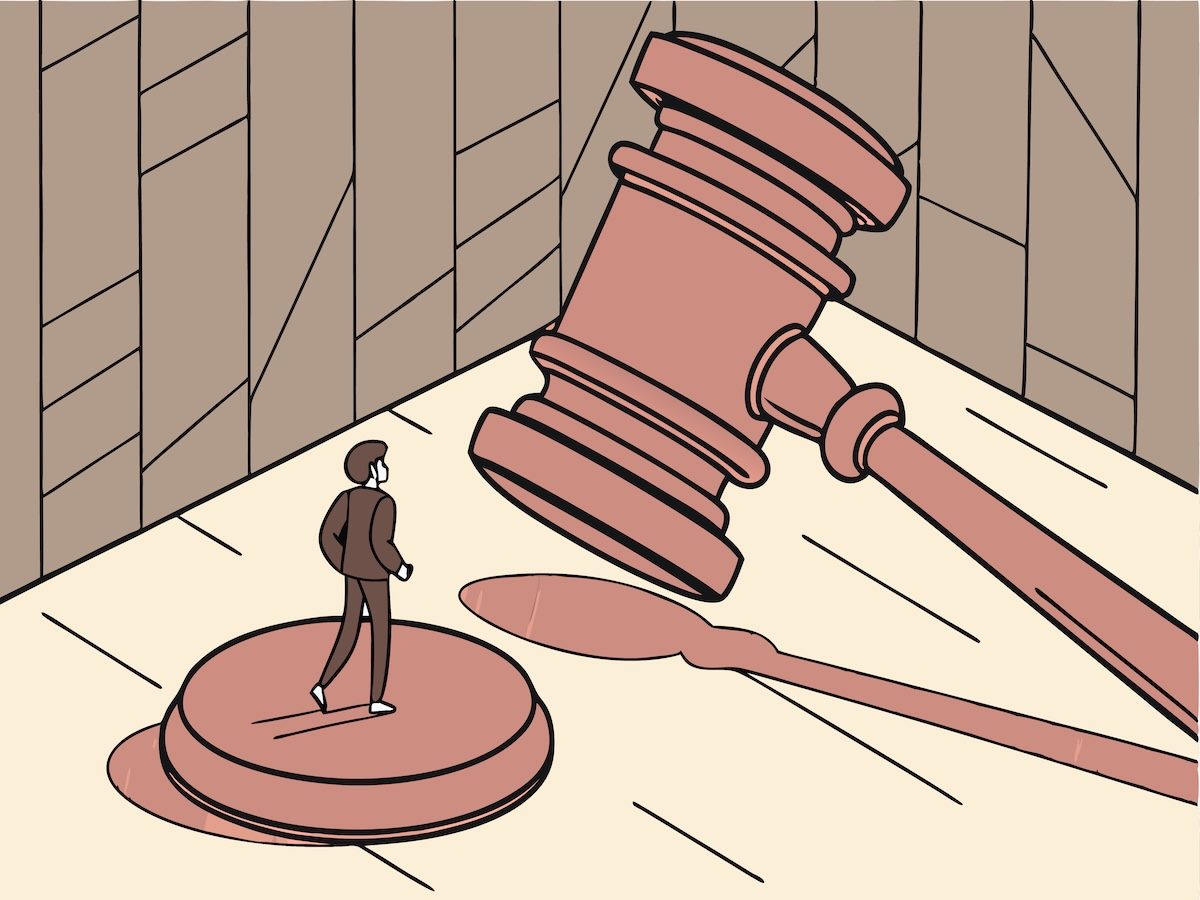 Illustration of a tiny businessman under a giant gavel