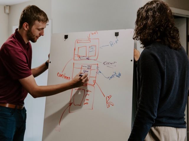 colleagues creating a wireframe on a whiteboard 