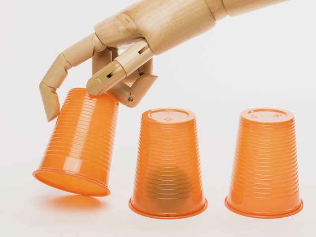 automaton hand playing variation of three card monte with cups