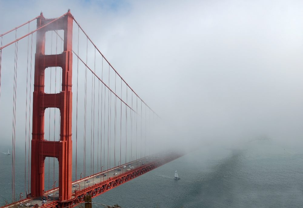 The Golden Gate Bridge in a heavy fog in piece about the unknown future of AI trends.
