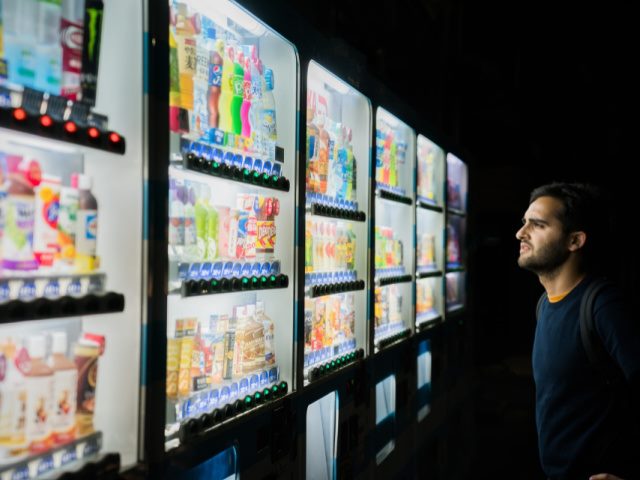 man standing in front of vending machines