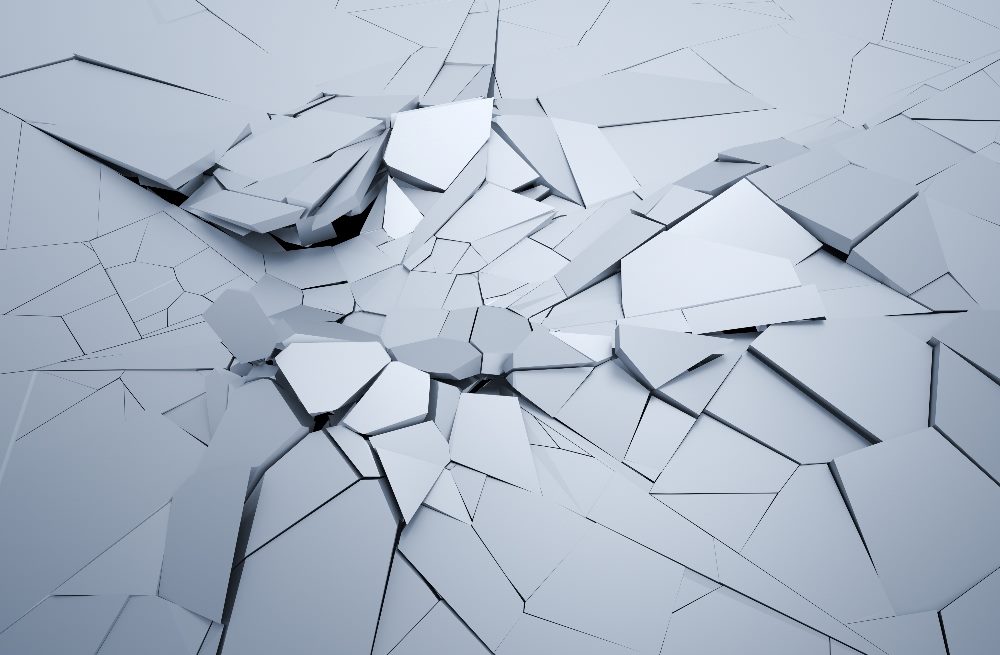 An image of a cracked, fragmented surface with irregularly shaped, angular pieces breaking apart. The surface appears to be a smooth, solid material, and the cracks radiate outward from a central point, suggesting disruption and instability. The overall color is a muted, cool gray, creating a stark and abstract visual representation of structural breakdown in piece about the impact of generative AI on the online economy.