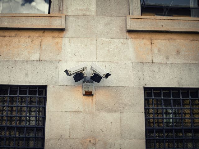 Security surveillance video cameras on the wall of a bank.