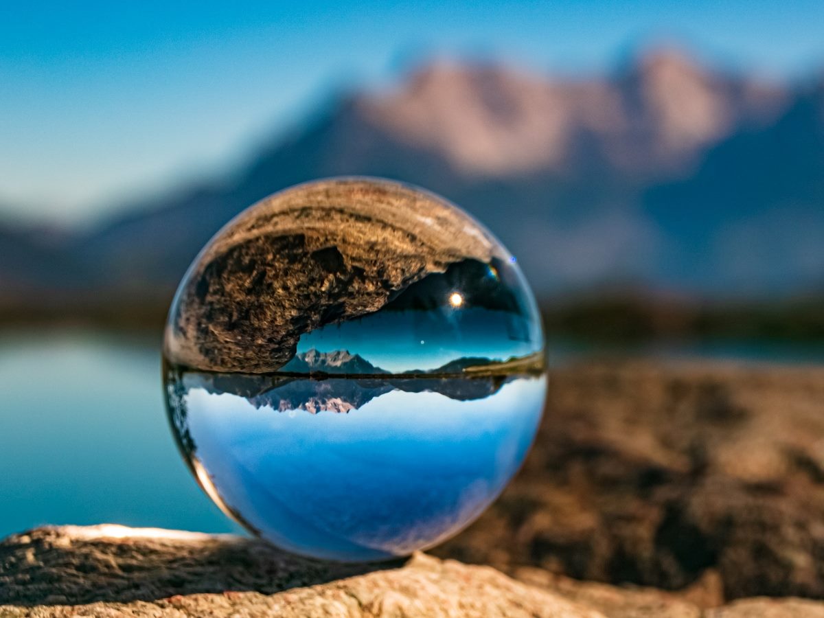 Crystal ball on a rock with the ocean as a backdrop.