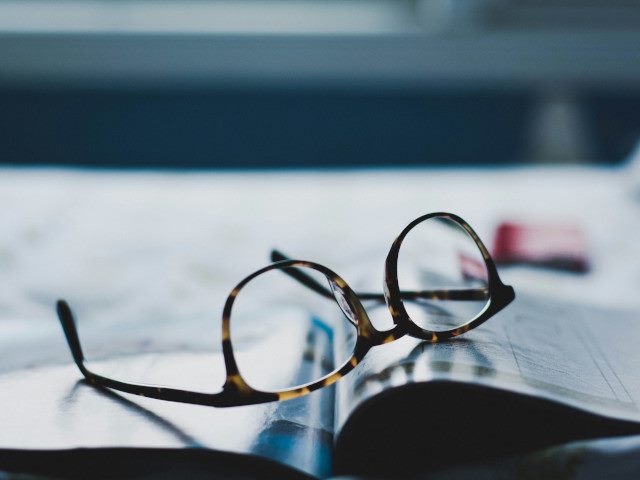 Eyeglasses on top of an open magazine.