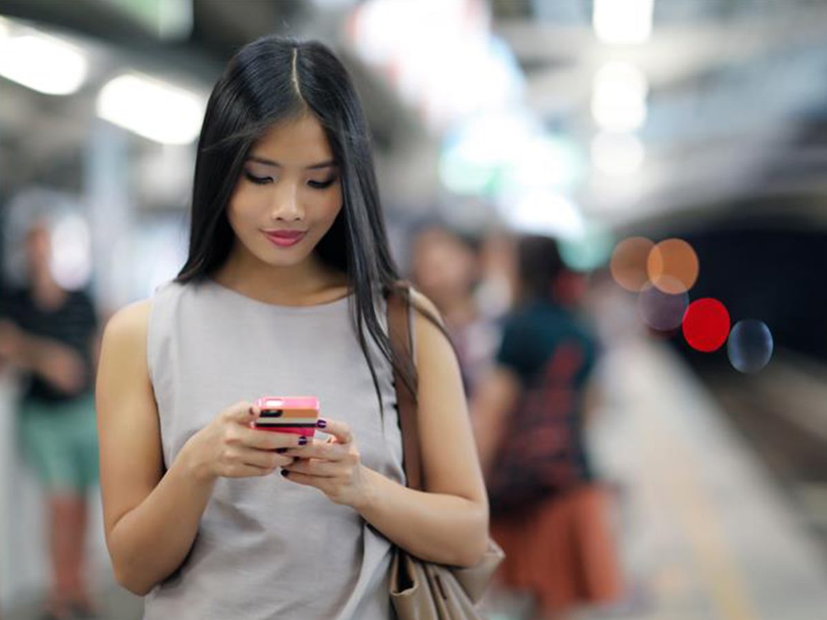 woman looking at her phone, smiling