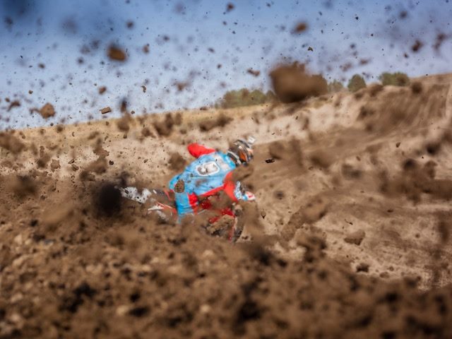 motorcycle kicking up mud into camera lens