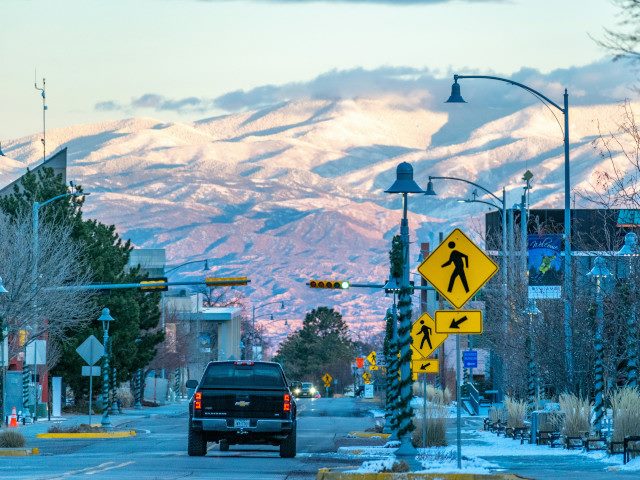A pickup truck on a road in Los Alamos New Mexico with a mountain in the background.