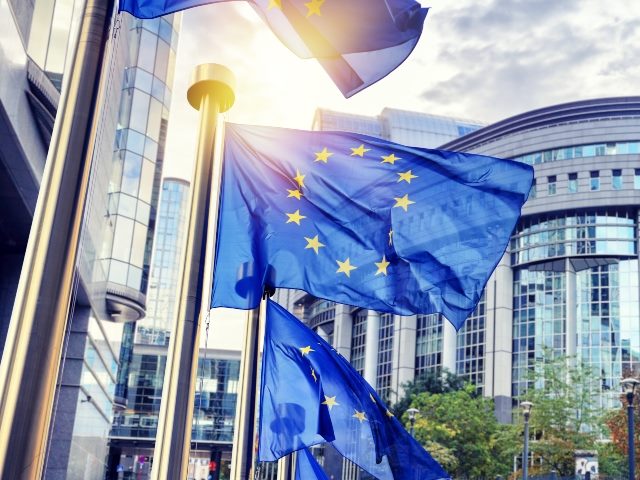 Flags waving in front of the European Parliament building in Brussels.